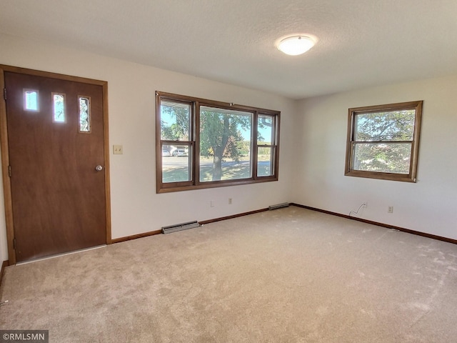 entryway featuring a healthy amount of sunlight, a textured ceiling, and carpet floors