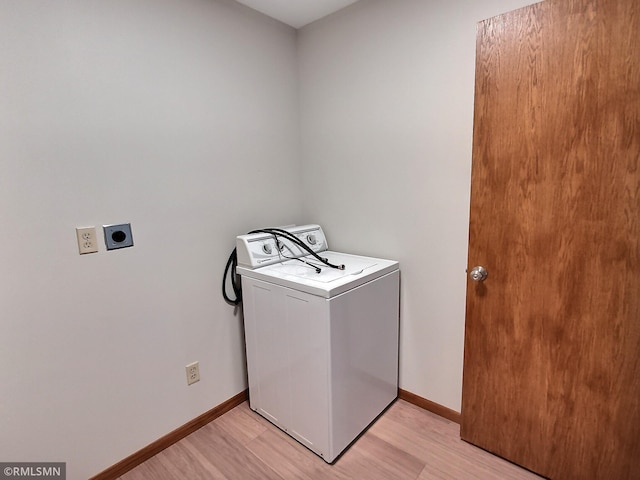 clothes washing area with washer / dryer and light wood-type flooring