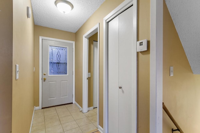 entryway with a textured ceiling and light tile patterned floors