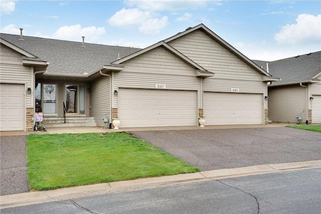 ranch-style house featuring a front lawn and a garage