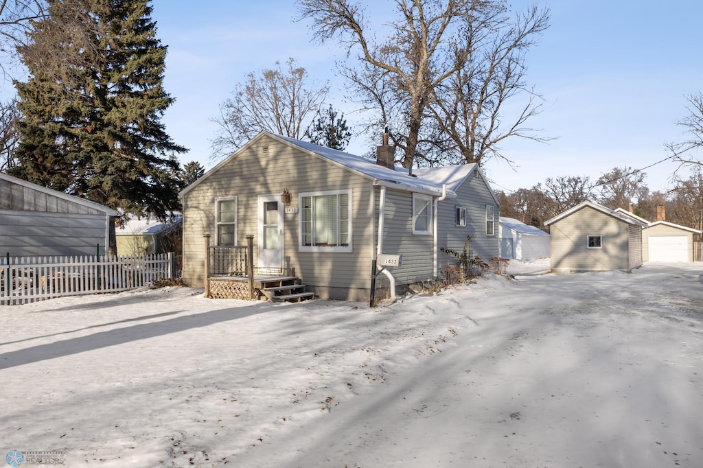 view of front facade with a garage and an outbuilding