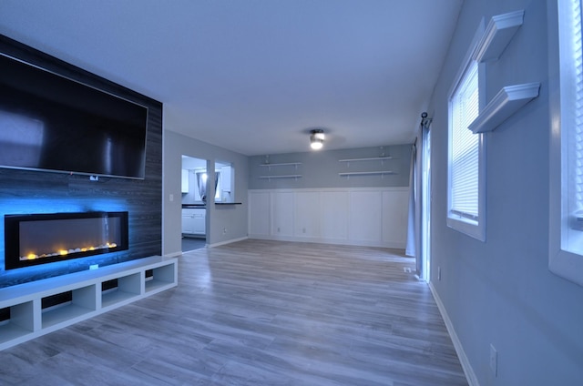 unfurnished living room featuring hardwood / wood-style flooring and a large fireplace