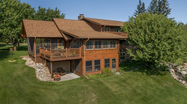 rear view of property with a yard, a patio area, and a sunroom