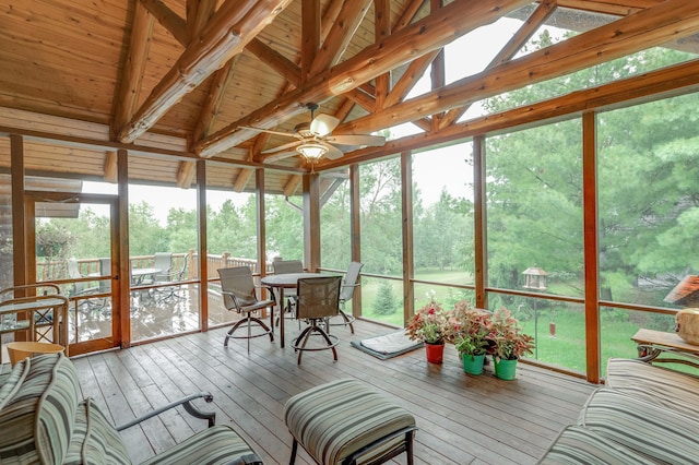 sunroom featuring ceiling fan, lofted ceiling with beams, and a wealth of natural light