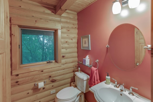 bathroom featuring wood ceiling, toilet, beam ceiling, sink, and rustic walls