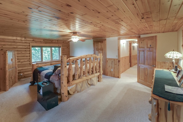 bedroom featuring wood ceiling, wooden walls, light colored carpet, and ceiling fan