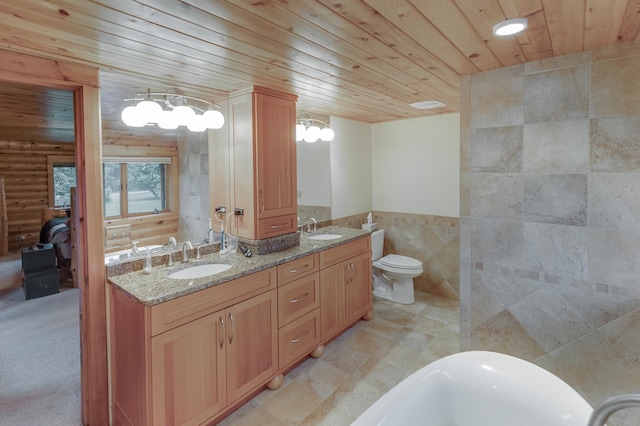 bathroom featuring a tub, toilet, wooden ceiling, tile walls, and vanity