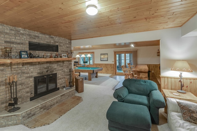 living room featuring pool table, carpet, wooden ceiling, a fireplace, and wooden walls