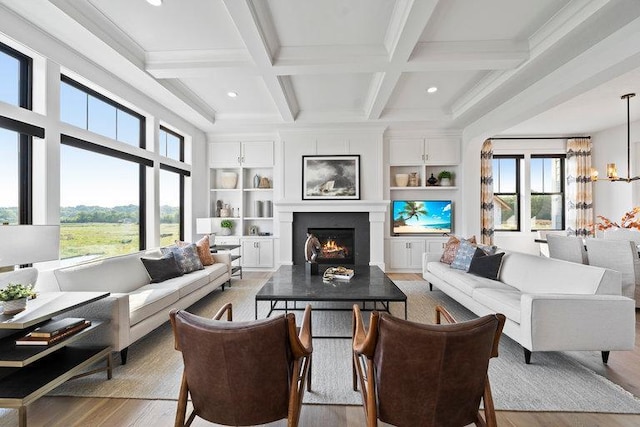 living room featuring beam ceiling, coffered ceiling, light hardwood / wood-style floors, and plenty of natural light