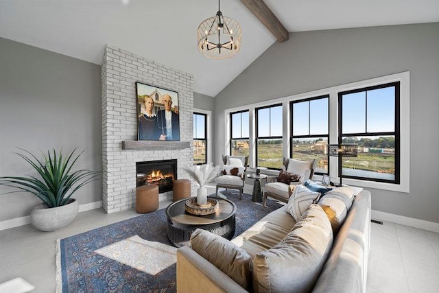 living room with a notable chandelier, lofted ceiling with beams, light tile patterned flooring, and a fireplace