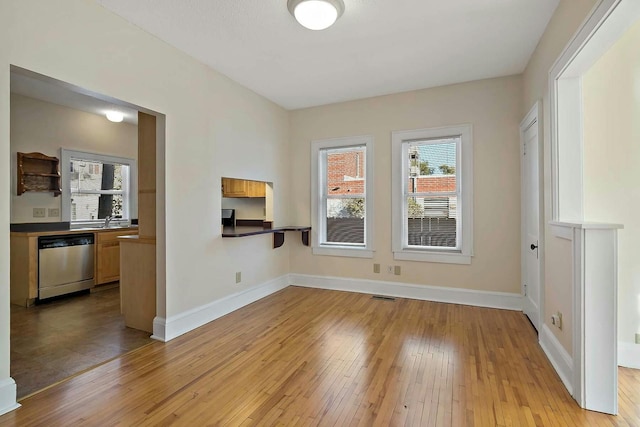 spare room featuring sink and light wood-type flooring