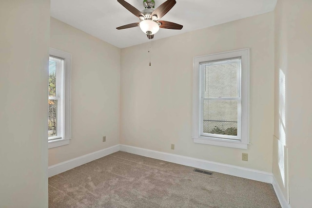 carpeted empty room with a healthy amount of sunlight and ceiling fan