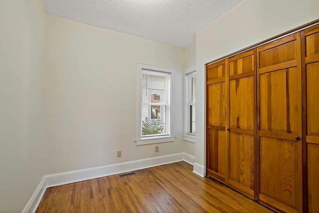 unfurnished bedroom featuring a textured ceiling and light wood-type flooring