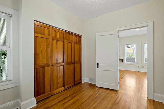 interior space with a textured ceiling and light hardwood / wood-style flooring