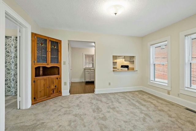 unfurnished living room featuring a textured ceiling and carpet floors