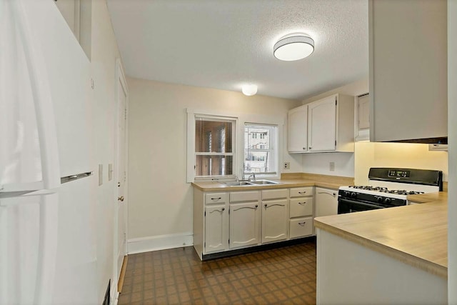 kitchen featuring sink, white cabinetry, a textured ceiling, and gas range gas stove