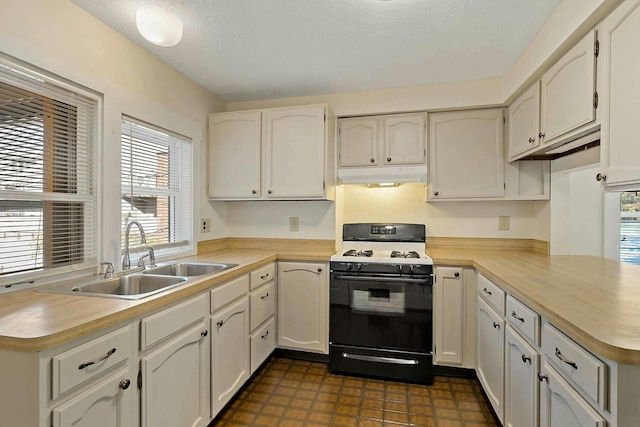 kitchen featuring white cabinetry, sink, kitchen peninsula, and black gas stove