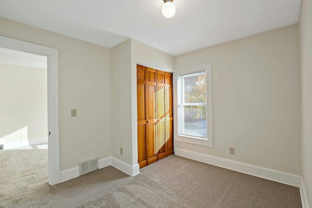 unfurnished bedroom featuring carpet floors and a closet