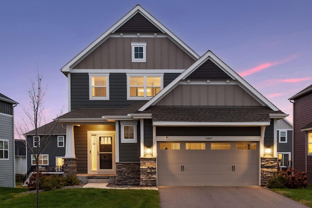 craftsman inspired home with a garage and a lawn