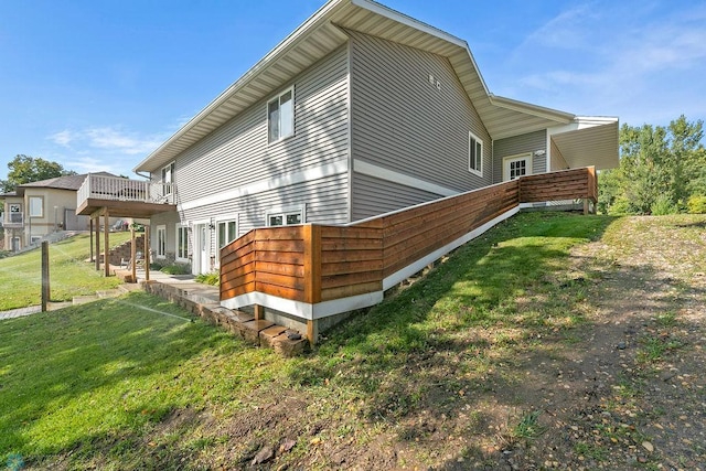 view of property exterior with a lawn and a wooden deck