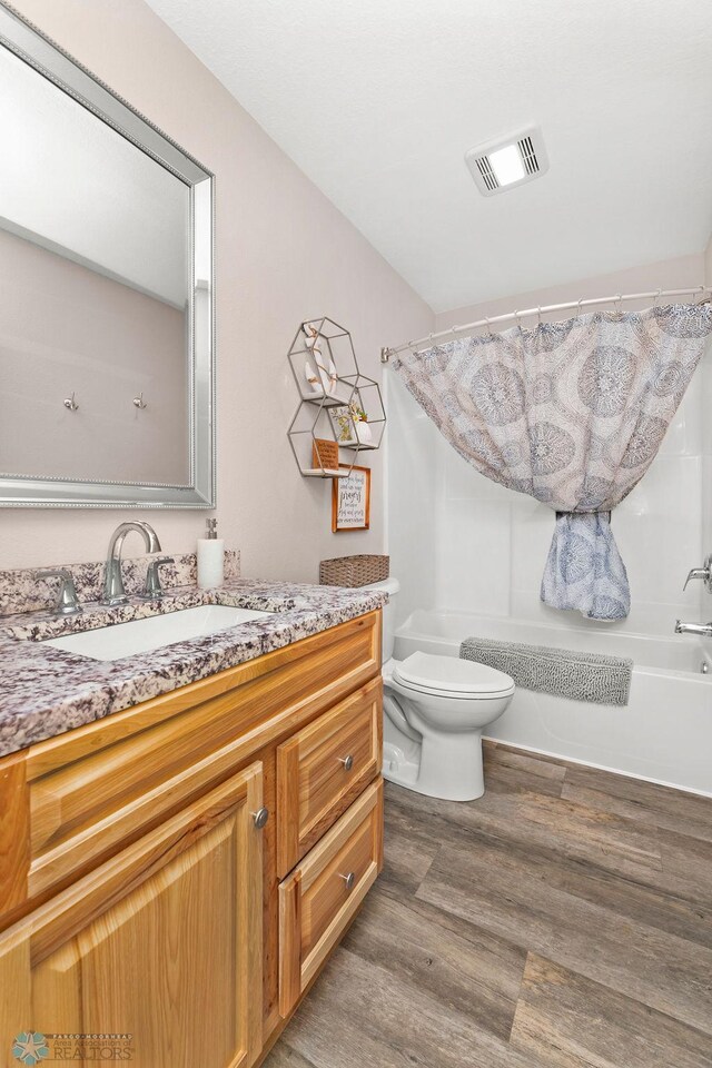 full bathroom featuring shower / tub combo, toilet, vanity, and hardwood / wood-style flooring