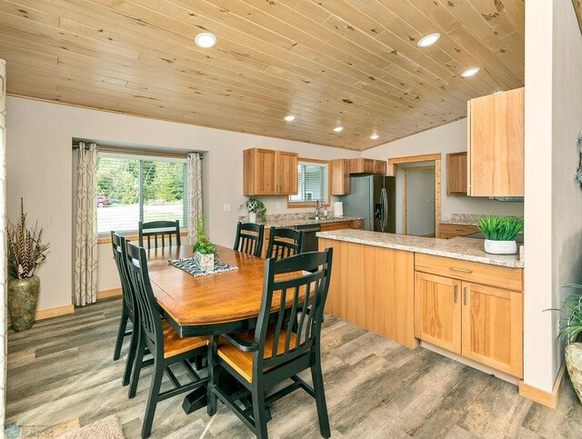 dining room featuring lofted ceiling, wooden ceiling, and light wood-type flooring