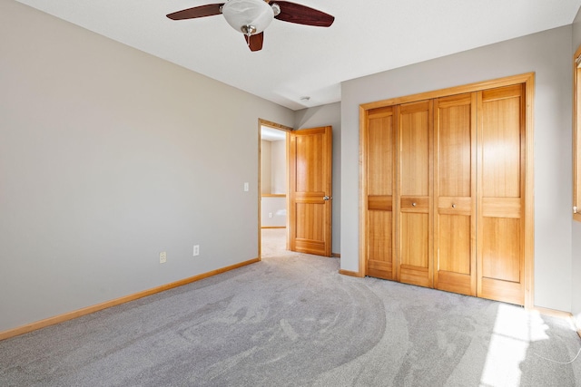 unfurnished bedroom with light carpet, ceiling fan, and a closet