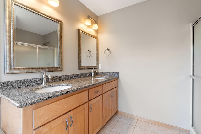 bathroom with walk in shower, vanity, and tile patterned flooring