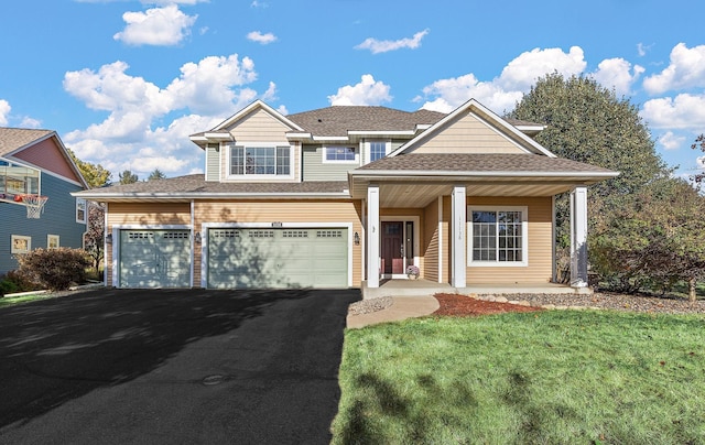 view of front of property with a front lawn, a garage, and covered porch