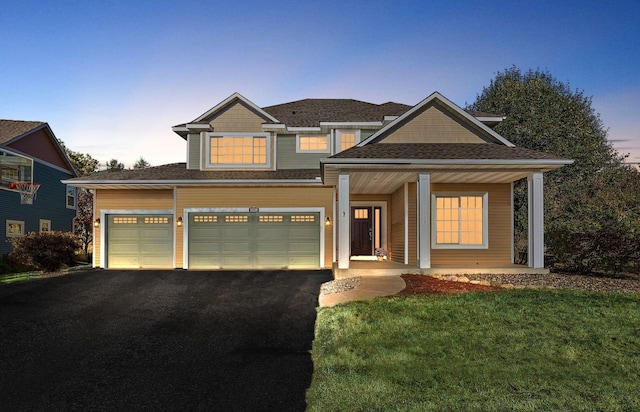 craftsman inspired home featuring covered porch, a garage, and a yard