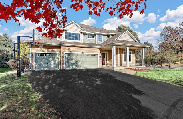 view of front of house featuring a garage, a porch, and a front lawn