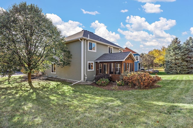 back of property featuring a sunroom and a yard