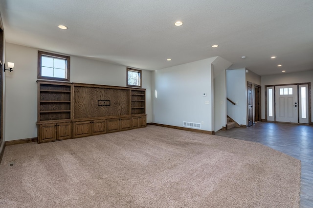 unfurnished living room featuring a textured ceiling and dark hardwood / wood-style flooring