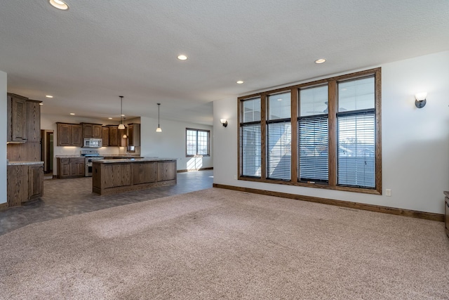 unfurnished living room featuring a textured ceiling and dark colored carpet