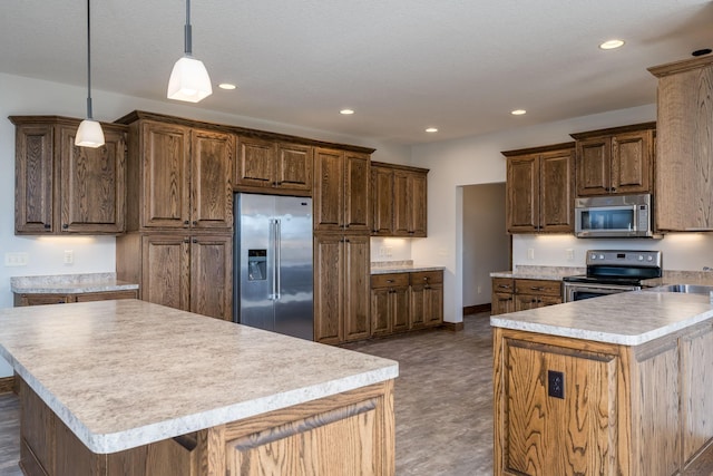 kitchen featuring stainless steel appliances, a textured ceiling, a center island, and hanging light fixtures