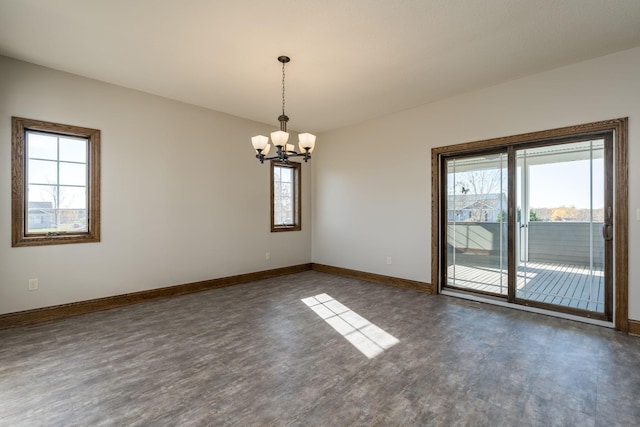 empty room with a chandelier and dark wood-type flooring