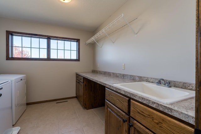 laundry room featuring sink, independent washer and dryer, light tile patterned floors, and cabinets