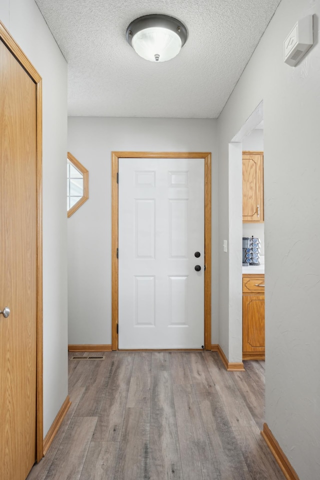 entryway featuring light hardwood / wood-style floors and a textured ceiling