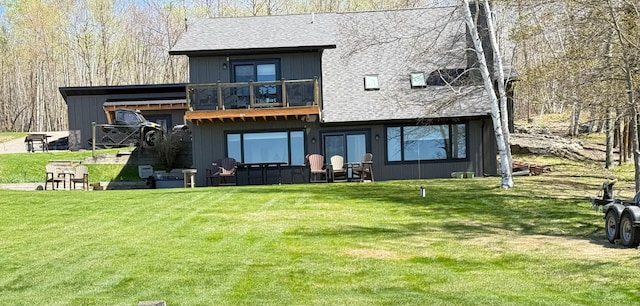 8291 Boy Lake Dr NE, Remer, MN 56672 - back of house featuring a lawn, a balcony, and a shingled roof