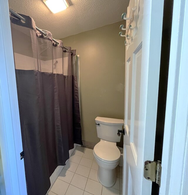 8291 Boy Lake Dr NE, Remer, MN 56672 - bathroom with toilet, tile patterned floors, a textured ceiling, and a shower with shower curtain