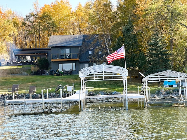 8291 Boy Lake Dr NE, Remer, MN 56672 - dock with boat lift, a balcony, a water view, a lawn, and view of scattered trees