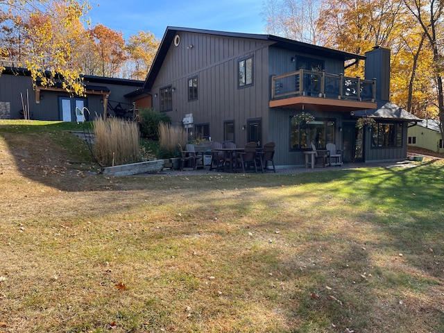 8291 Boy Lake Dr NE, Remer, MN 56672 - back of house featuring a balcony, a patio area, and a lawn