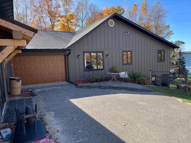 8291 Boy Lake Dr NE, Remer, MN 56672 - view of front facade with a garage, board and batten siding, a shingled roof, and asphalt driveway