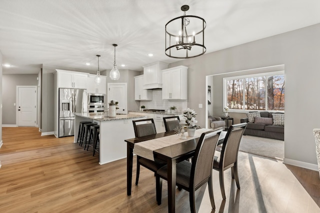 dining space with a chandelier and light wood-type flooring