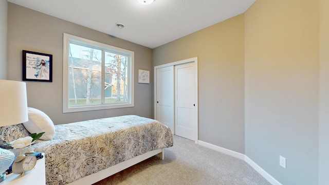 bedroom with light carpet and a closet