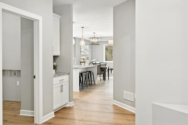 corridor with light hardwood / wood-style flooring