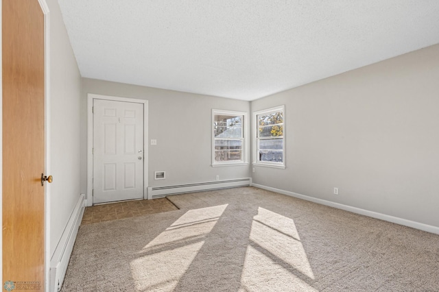 carpeted spare room featuring a textured ceiling and a baseboard radiator