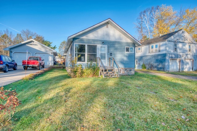 view of front facade featuring a front yard, a garage, and an outbuilding