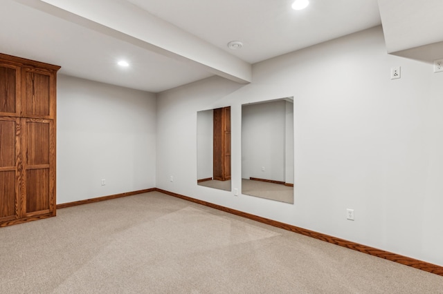 interior space featuring light colored carpet and beam ceiling