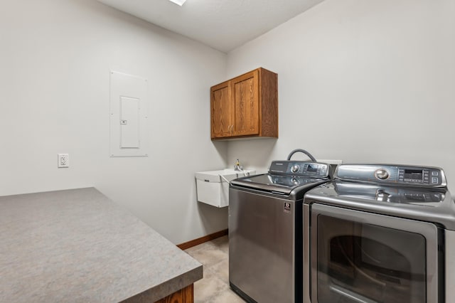 laundry area featuring electric panel, cabinets, sink, and independent washer and dryer